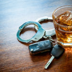 dui concept shown by keys, handcuffs, and whiskey