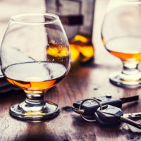 DUI concept shown with two drinks, cognac, and keys