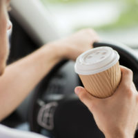 Man drinking coffee while driving