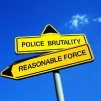 road signs that read police brutality and reasonable force